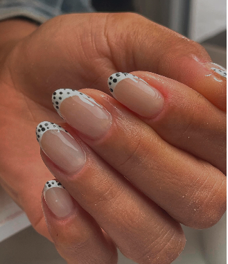 French branca com pormenor de bolinhas pretas em unhas amendoadas